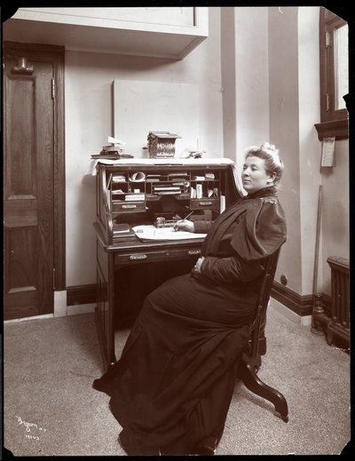 Portret van een niet-geïdentificeerde vrouw aan een bureau in een kantoor in New York, 1904 door Byron Company